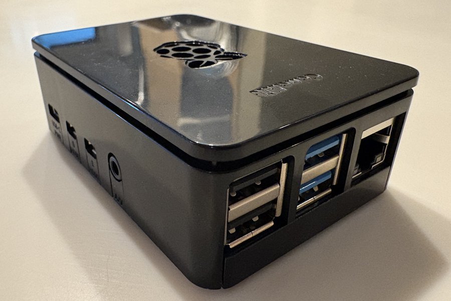 The High Performance computer: a small single-board computer in a gloss black case embossed with the Raspberry Pi logo, showing two USB 2.0 ports, two blue USB 3.0 ports and an Ethernet socket.