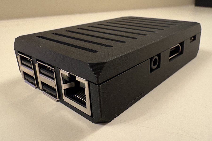 The Standard computer: a small single-board computer in a matte black ribbed case, with its four USB ports, Ethernet socket, HDMI output and headphone jack along the edges.